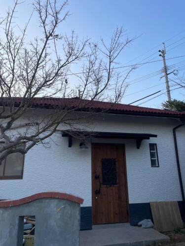 a white house with a wooden door on it at Kitakyushu - House - Vacation STAY 18471 in Kitakyushu