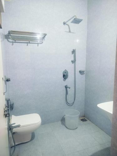 a bathroom with a shower and a toilet and a sink at Hotel Golden Buddha Inn Bodhgaya in Bodh Gaya