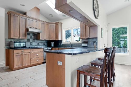a kitchen with wooden cabinets and a kitchen island with chairs at Lake Shore Living in Michiana