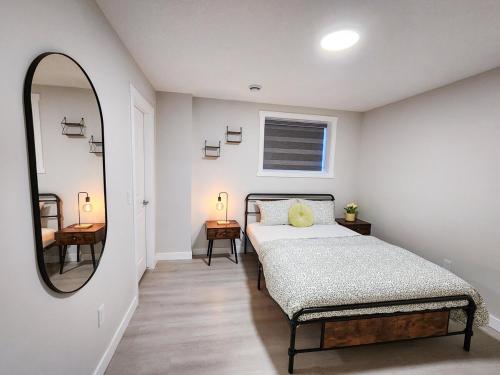 a bedroom with a bed and a large mirror at Calgary Cozy Nest 2BR Suite in Calgary