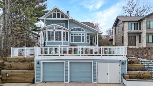 a blue house with a deck and two garage doors at Lake Shore Living in Michiana
