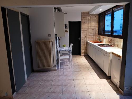 une cuisine avec un évier et une table à l'intérieur dans l'établissement Résidence le Cerdagne, à Colomiers