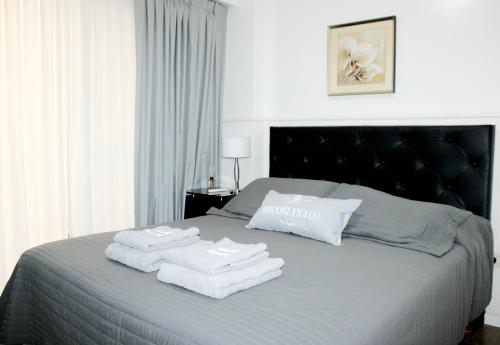 a bedroom with a bed with towels on it at Apartamento moderno en Las Cañitas, Palermo in Buenos Aires