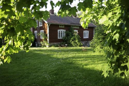 a house with a large yard in front of it at Osaby Säteri in Tävelsås