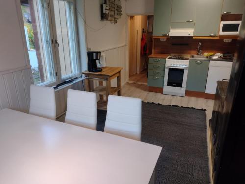 una cocina con mesa y sillas blancas. en A place of peace for your holiday!, en Kontiolahti