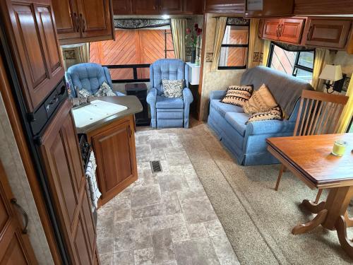 a living room with a couch and chairs and a table at Outpost RV Accomodation Fiordland in Te Anau
