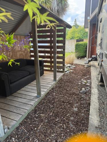 a backyard with a couch on a wooden deck at Outpost RV Accomodation Fiordland in Te Anau