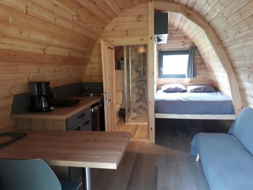 a room with a bed and a table in a cabin at Un petit coin de paradis dans les Cévennes in Saint-Germain-de-Calberte