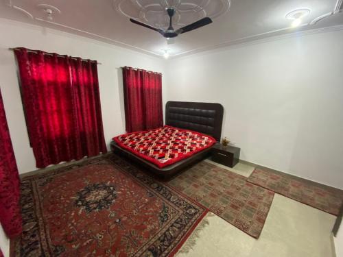 a room with a bed with red curtains and a rug at Visiting Villa in Srinagar