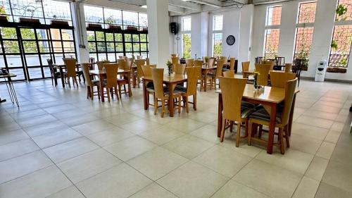 a dining room with tables and chairs and windows at Hotel San Pedro del Fuerte in Medellín