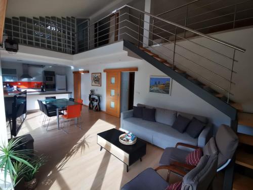 a living room with a blue couch and a kitchen at Casa da Ponte in Troporiz