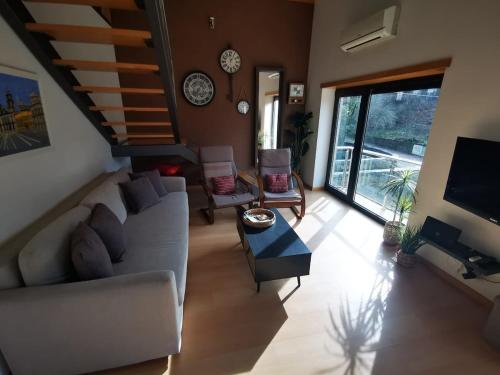 a living room with a couch and a tv at Casa da Ponte in Troporiz