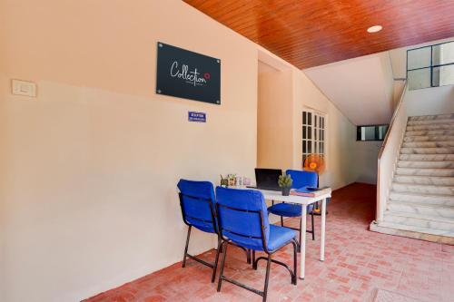 a dining room with blue chairs and a table at Super Collection O Sri Balaji Luxury rooms in Kondapur