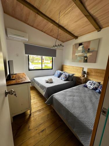 ein Schlafzimmer mit zwei Betten und einem Fenster in der Unterkunft Villa Victoria in Manantiales