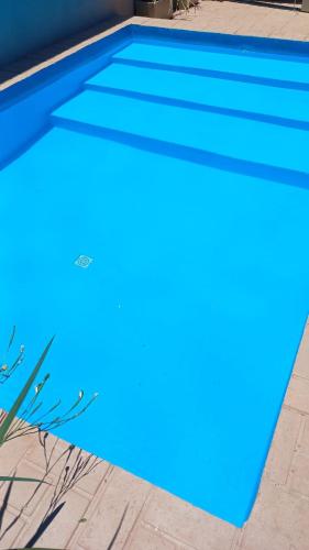 a swimming pool with blue water in front of a house at Brisas Iguazú II in Puerto Iguazú
