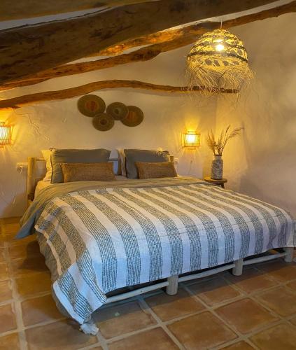 a bedroom with a bed and a chandelier at Cortijo La Pedriza in Iznájar