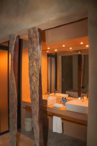 a bathroom with two sinks and two mirrors at Hotel Maya Bell in Palenque