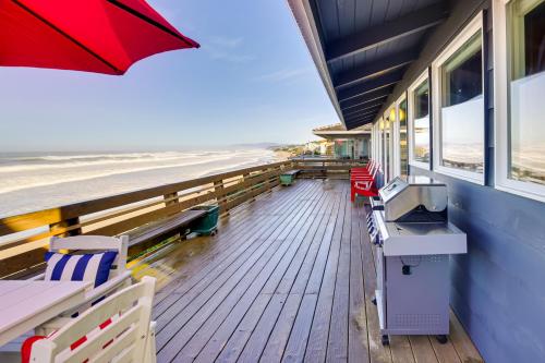 a deck with chairs and an umbrella on the beach at Private Beach Access Serene Escape in Depoe Bay in Depoe Bay