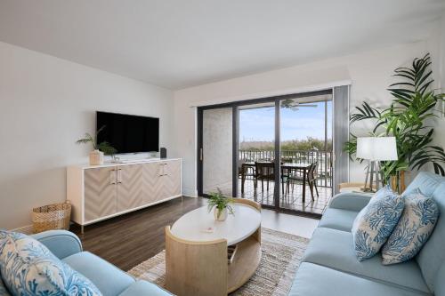 a living room with a blue couch and a table at South Seas Bayside Villa 4116 - Newly Renovated Marina View Condo in Captiva