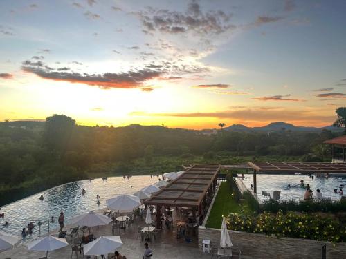 a view of a pool at a resort at sunset at Resort QSB - Um novo padrão de conforto e lazer no coração da cidade in Pirenópolis