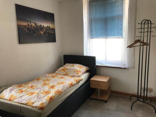 une petite chambre avec un lit et une fenêtre dans l'établissement Pension Hanoi, à Hettstedt