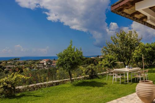 a patio with a table and a view of the ocean at Pantheon Villa Svoronata in Svoronata