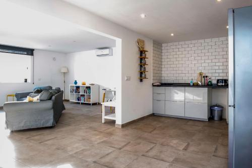 a living room with a couch and a kitchen at Open and large 1 bed apartment in L'Alfas del Pi