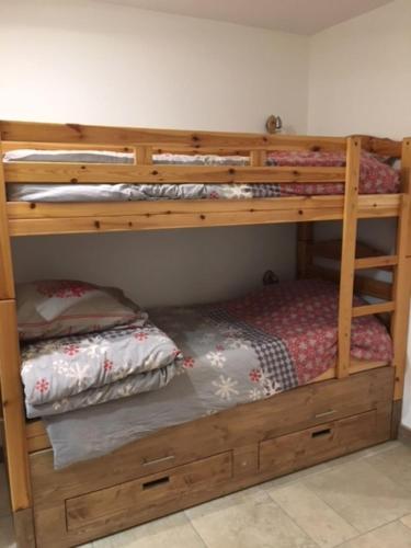 - un lit superposé en bois avec un lit en dessous dans l'établissement Appartement de charme familial aux CARROZ d ARACHES, à Arâches-la-Frasse
