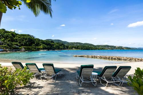 a group of chairs sitting on a beach at Round Hill Hotel & Villas in Montego Bay