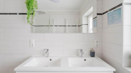 biała łazienka z dwiema umywalkami i lustrem w obiekcie Moderne Ferienwohnung mit Bergblick w mieście Bad Goisern