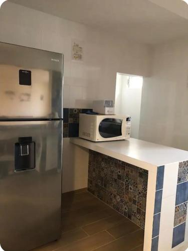 a kitchen with a refrigerator and a microwave on a counter at Habitación privada Depa B in Jardines de la Hacienda