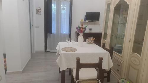 a table with a white table cloth and two chairs at Domu Loca in Pula