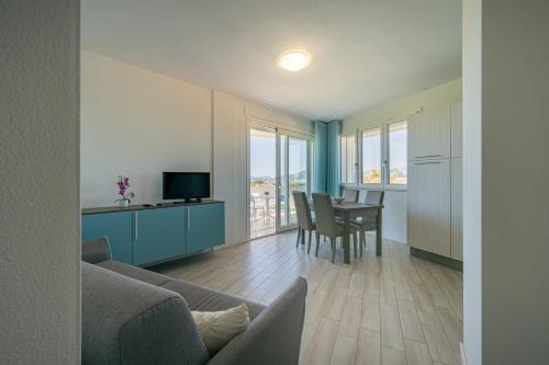 a living room with a couch and a table with chairs at Milena Suite Apartments in Alghero