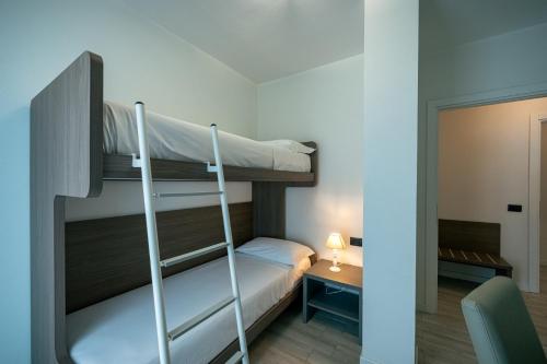 a room with two bunk beds and a desk at Milena Suite Apartments in Alghero