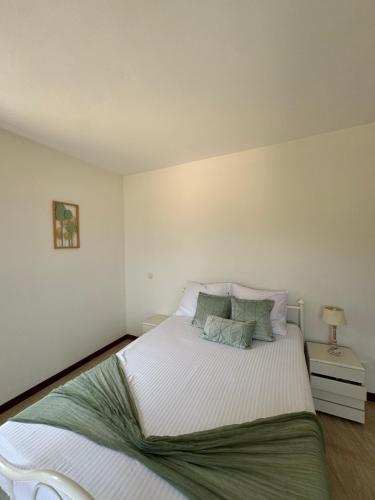 a bedroom with a large white bed with two pillows at Casa Carveiros Panoramic 360 in Tarrafal