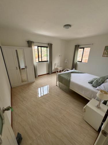 a large bedroom with a large bed and two windows at Casa Carveiros Panoramic 360 in Tarrafal