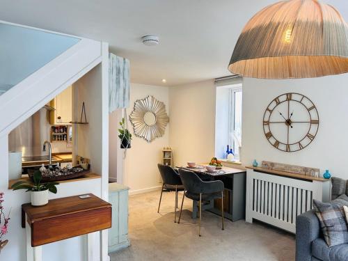 a kitchen and living room with a table and a clock at The Old Post Office - MaisonPro in Stroud