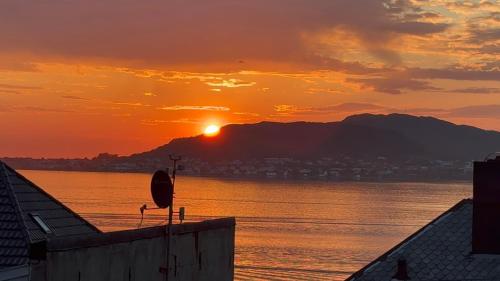 a sunset over a body of water with a mountain at Apartment with a beautiful view in the center of Ålesund in Ålesund