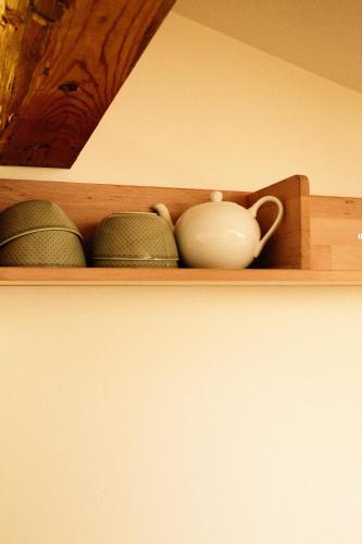 a shelf with a white pitcher and bowls on it at Tanafreida Berg-Refugium in Sankt Gallenkirch