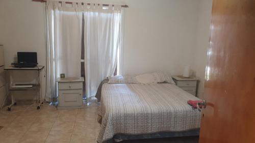 a small bedroom with a bed and a window at Casa pali in Miramar