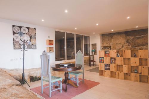 a room with a table and two chairs and a wall of glass at Fraga`s House - Douro e Natureza in Coura