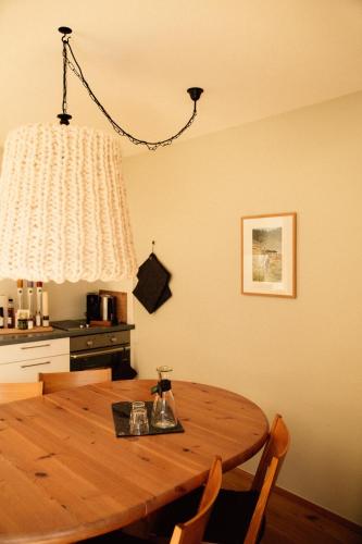 a wooden dining room table with chairs and a chandelier at Tanafreida Berg-Refugium in Sankt Gallenkirch