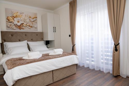 a bedroom with a large bed with two towels on it at Hotel Alibabin Raj in Konjic