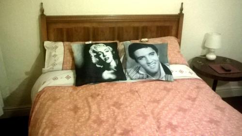 a bed with two black and white photographs on the pillows at The Albert Hotel Near Winter Gardens in Blackpool