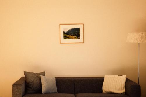 a living room with a couch and a picture on the wall at Tanafreida Berg-Refugium in Sankt Gallenkirch