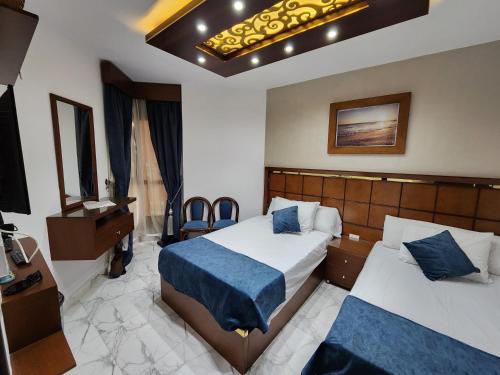 a hotel room with two beds and a television at Porto said بورتوسعيد شاليه غرفه وصاله للأسر فقط in `Ezbet Shalabi el-Rûdi