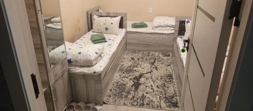 a small room with two beds and a mirror at Oltin Vodiy hostel in Fergana