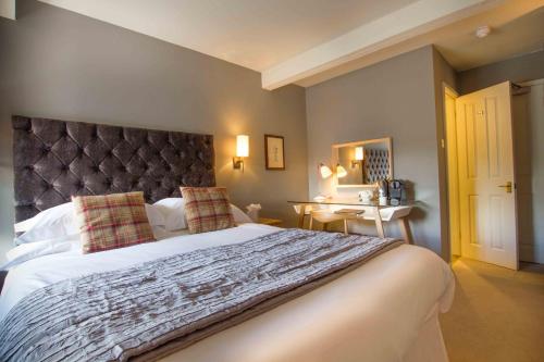 a bedroom with a large bed and a mirror at Crown & Punchbowl in Cambridge