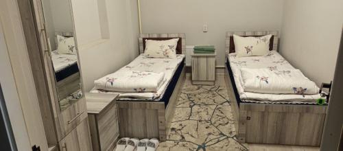 a room with two beds and a mirror at Oltin Vodiy hostel in Fergana