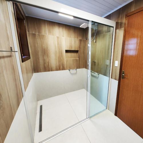 a shower with a glass door in a bathroom at Pousada Casa dos Sonhos in Campos do Jordão